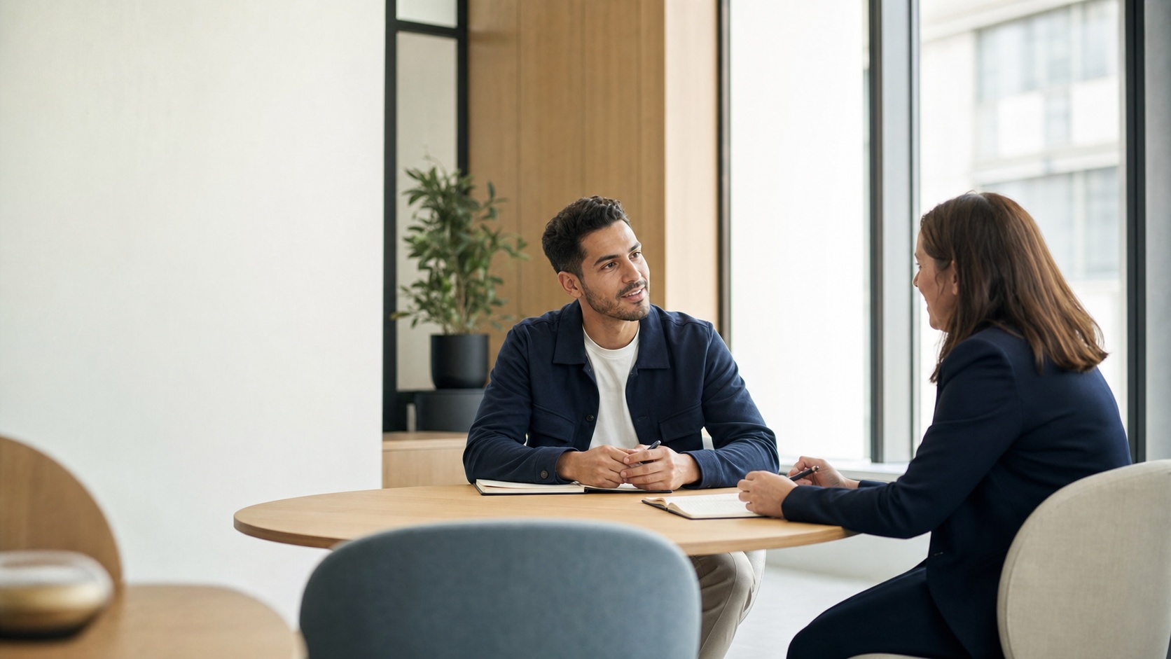Entretien RH entre une candidate et un recruteur après la réussite d’un entretien technique, dans un bureau moderne lumineux.