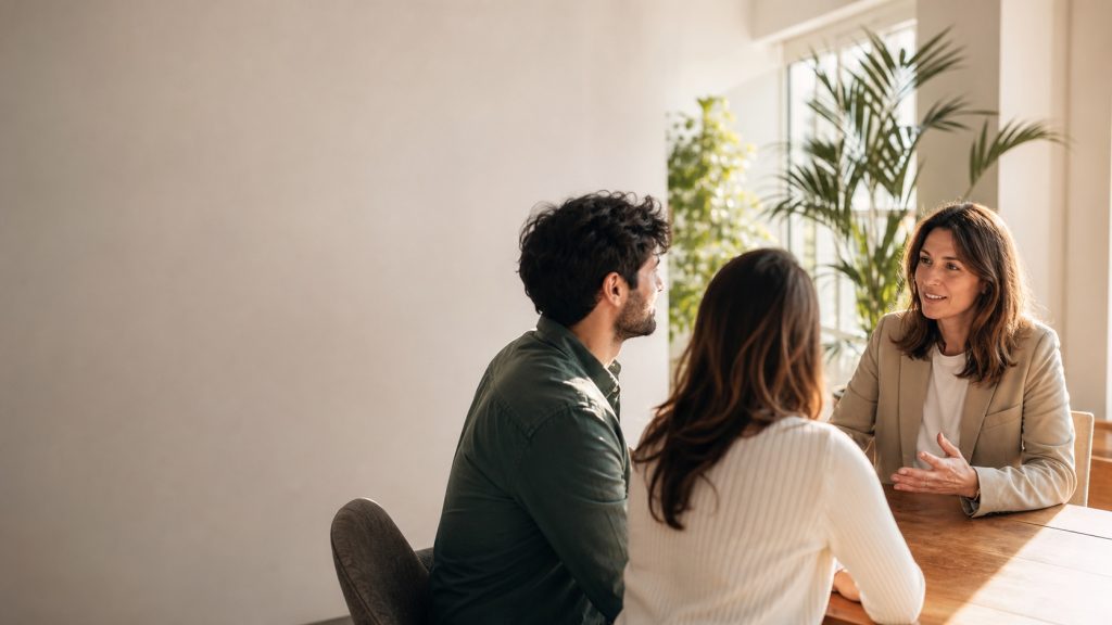 Réunion entre une responsable RH et deux salariés dans un bureau lumineux, illustrant la mutuelle obligatoire des entreprises.